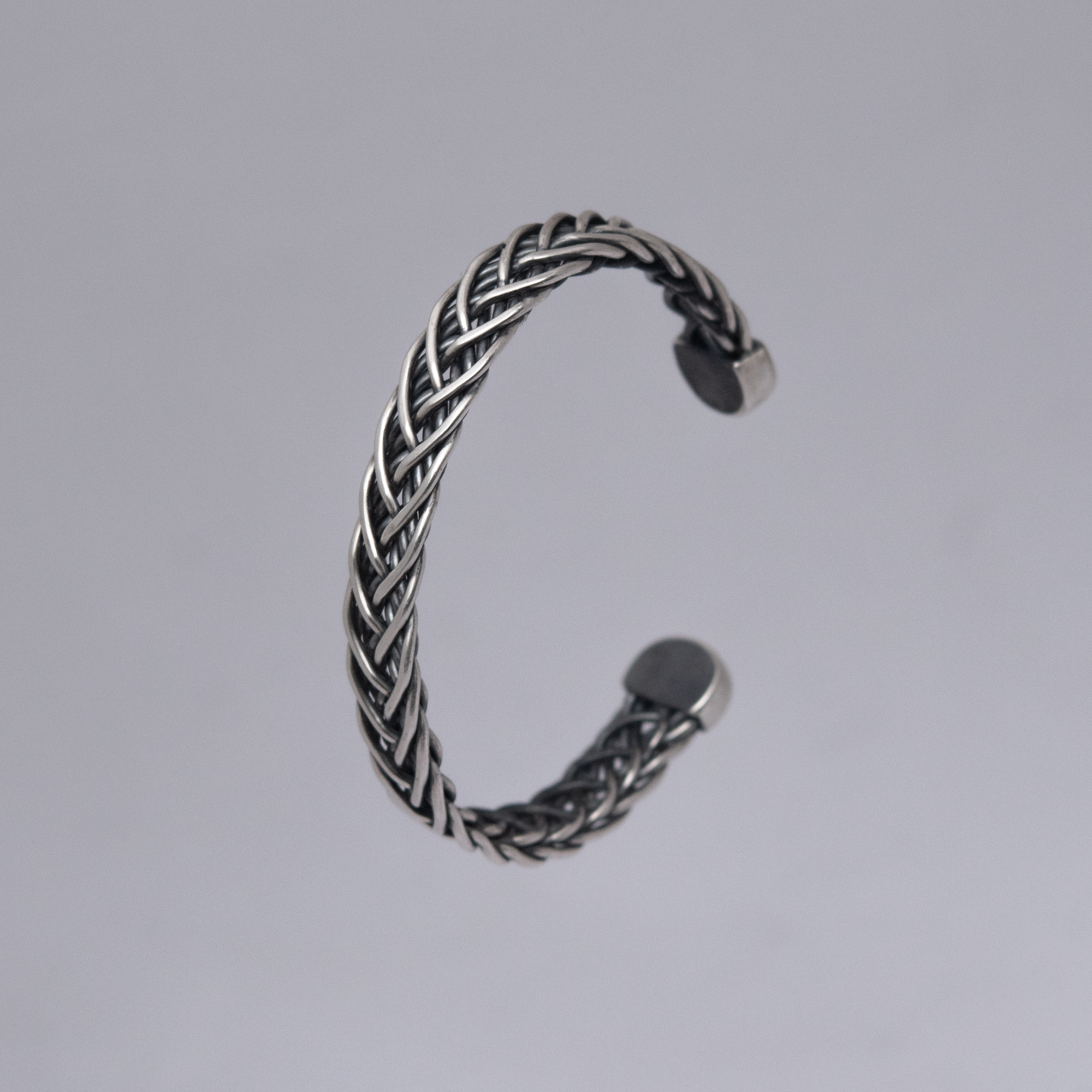 An image of the Dunloe Cuff showing its intricate sterling silver weave, as well as the hand fabricated end caps. 