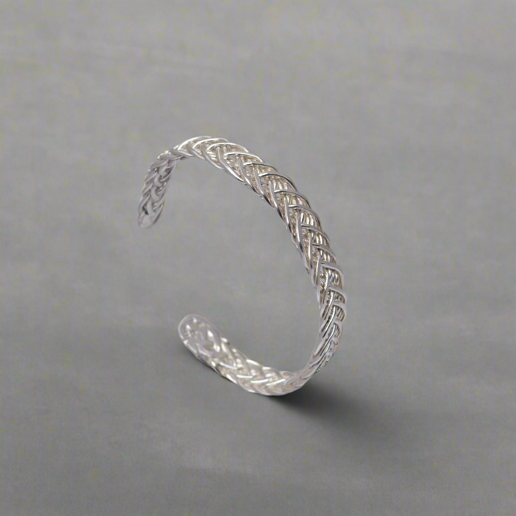 An image of the shiny silver Kinsale cuff, a woven sterling silver cuff made of 10 wires with forged tapered ends.