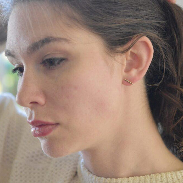 Image shows 18 karat gold square wire ½ inch earrings on a model for scale