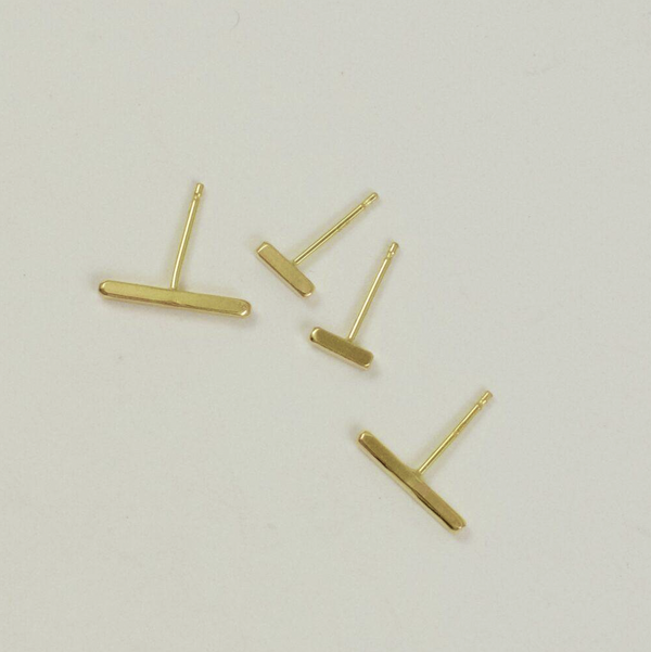 Flat lain photo of both sizes of the 18 karat gold square wire stud earrings that shows the relative size difference.